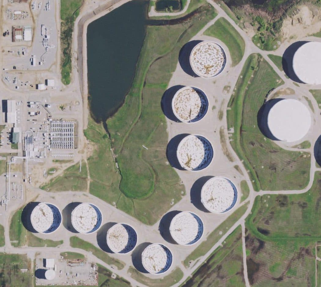 Aerial view of floating-roof oil tanks in Cushing, Oklahoma, each with a shadow crescent on its roof