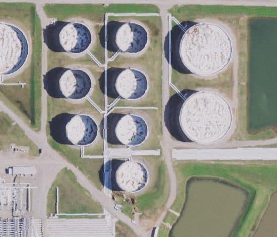 Floating-roof oil tanks seen from above, with shadow crescents of different sizes